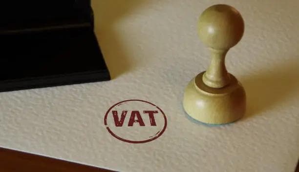VAT stamp on a document beside a wooden seal, representing VAT filing and tax registration done smoothly by Timber Accounting service.